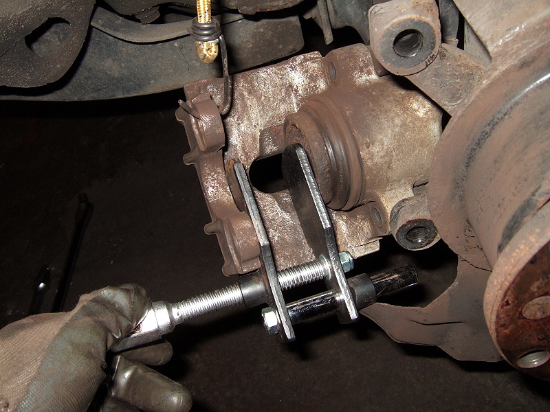 Press back the caliper piston into the brake caliper (to make room for